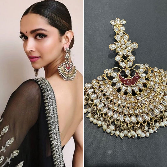 Woman wearing a black saree with gold jewelry, including earrings and a necklace.