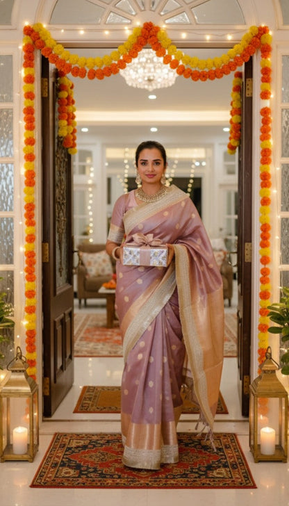 Woman in a lavendar saree standing in a decorated room with floral decorations and candles.